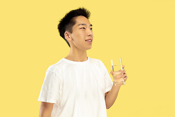 Image showing Korean young man\'s half-length portrait on yellow background