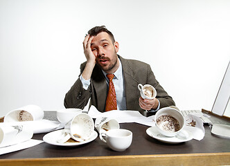 Image showing Young man drinking a lot of coffee