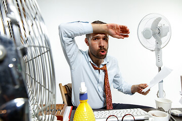 Image showing Young man ssuffering from the heat in the office