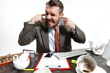 Image showing Young man suffering from the talks in the office