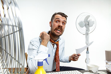 Image showing Young man ssuffering from the heat in the office