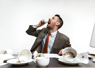 Image showing Young man drinking a lot of coffee