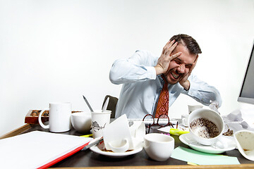 Image showing Young man suffering from the noise in the office