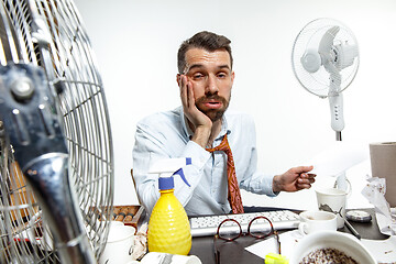 Image showing Young man ssuffering from the heat in the office