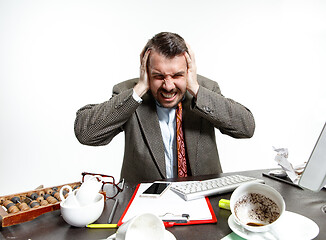 Image showing Young man suffering from the talks in the office