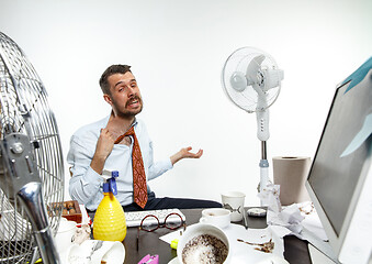 Image showing Young man ssuffering from the heat in the office