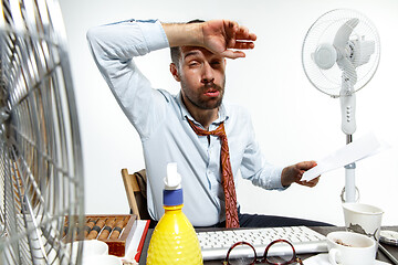 Image showing Young man ssuffering from the heat in the office