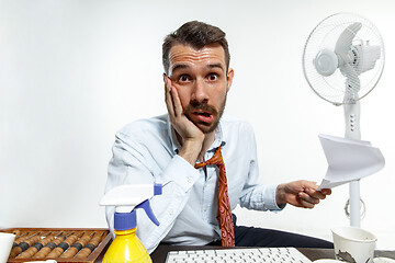 Image showing Young man ssuffering from the heat in the office