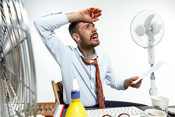 Image showing Young man ssuffering from the heat in the office