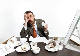 Image showing Young man drinking a lot of coffee