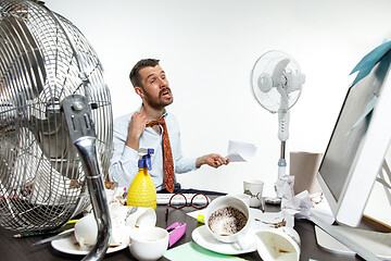 Image showing Young man ssuffering from the heat in the office