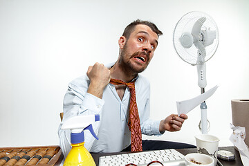 Image showing Young man ssuffering from the heat in the office