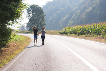 Image showing young couple jogging along a country road