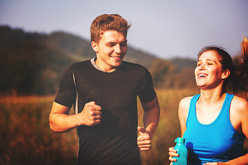 Image showing young couple jogging along a country road