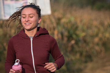 Image showing woman jogging along a country road