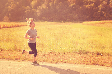 Image showing woman jogging along a country road