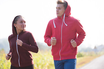 Image showing young couple jogging along a country road