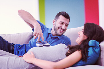 Image showing young pregnant couple relaxing on sofa