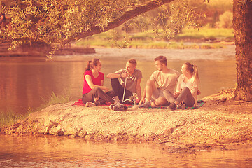 Image showing friends smoking hookah on the river bank