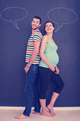 Image showing pregnant couple writing on a black chalkboard