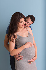 Image showing pregnant couple  isolated over blue background