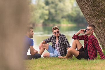 Image showing men sitting on the bank of the river