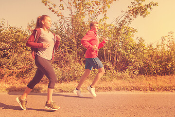 Image showing young couple jogging along a country road