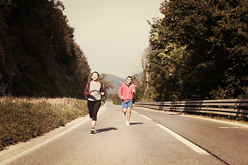 Image showing young couple jogging along a country road