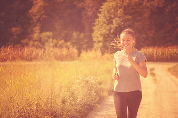 Image showing woman jogging along a country road