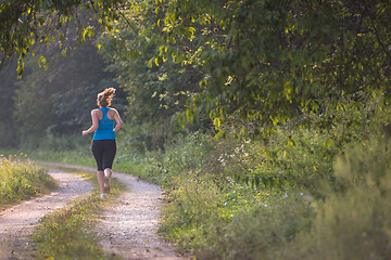 Image showing woman jogging along a country road