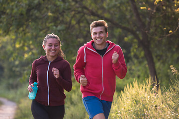 Image showing young couple jogging along a country road