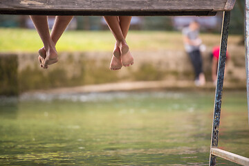 Image showing people sitting at wooden bridge