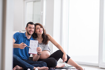 Image showing pregnant couple checking a list of things for their unborn baby