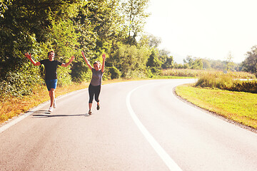 Image showing young couple jogging along a country road