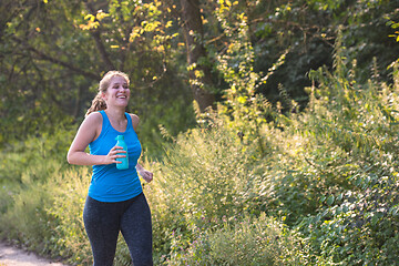 Image showing woman jogging along a country road