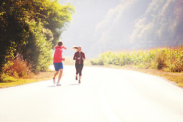 Image showing young couple jogging along a country road