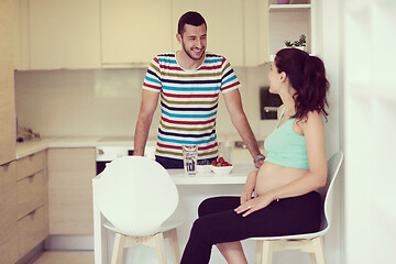 Image showing couple eating fruit strawberries at kitchen