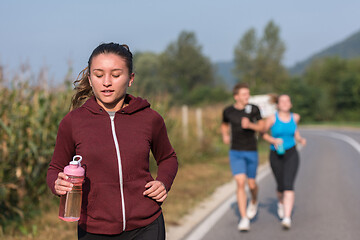 Image showing young people jogging on country road