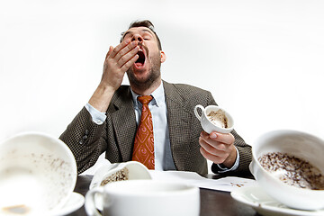 Image showing Young man drinking a lot of coffee