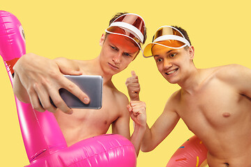 Image showing Two young men isolated on yellow studio background