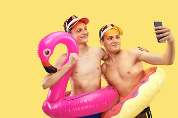 Image showing Two young men isolated on yellow studio background