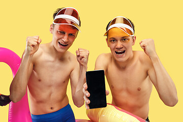 Image showing Two young men isolated on yellow studio background