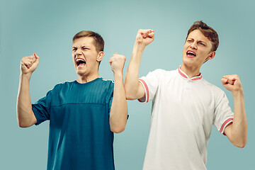 Image showing Two young men isolated on blue background