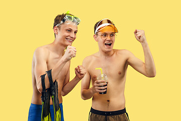 Image showing Two young men isolated on yellow studio background