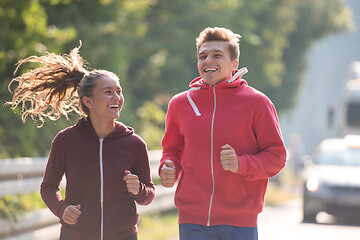 Image showing young couple jogging along a country road