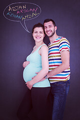 Image showing pregnant couple writing on a black chalkboard