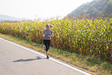 Image showing woman jogging along a country road