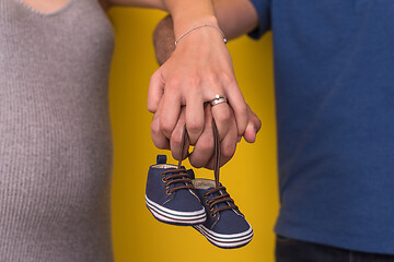 Image showing couple holding newborn baby shoes