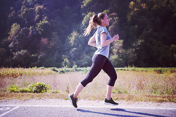 Image showing woman jogging along a country road