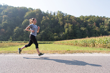 Image showing woman jogging along a country road